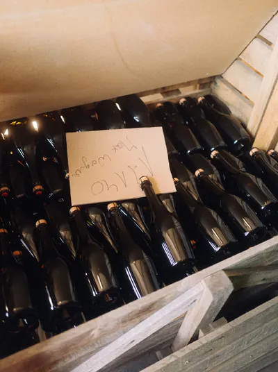 Wooden crate full of sparkling wine bottles with a handwritten note