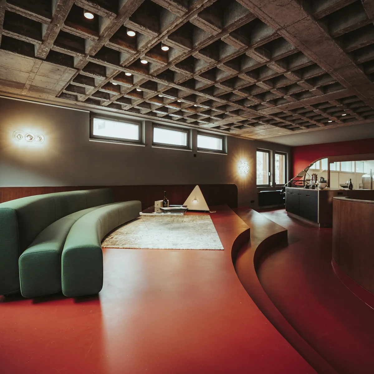 Lounge with a green sofa and red floor at the winery