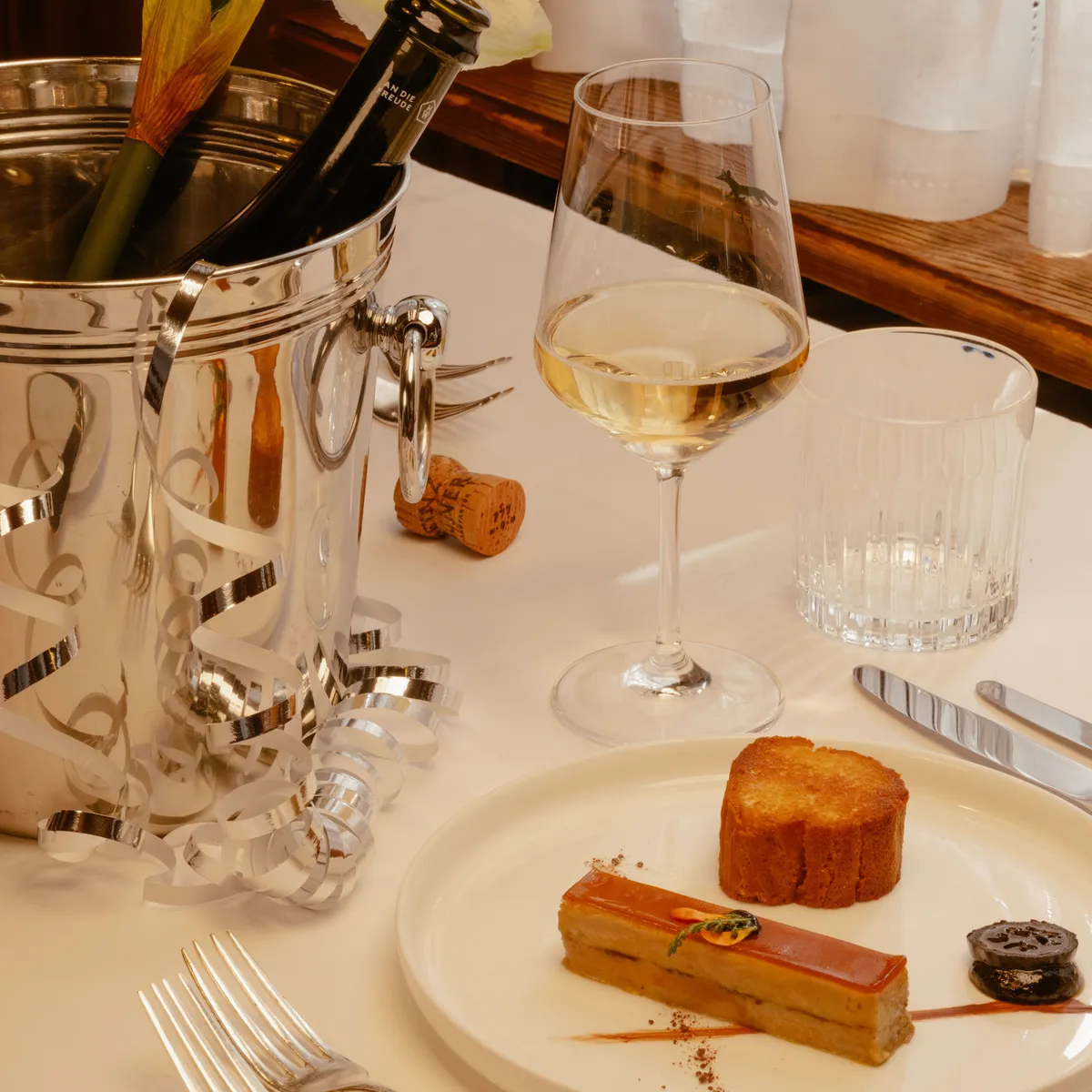 Set table with an ice bucket, a wine glass and a dessert