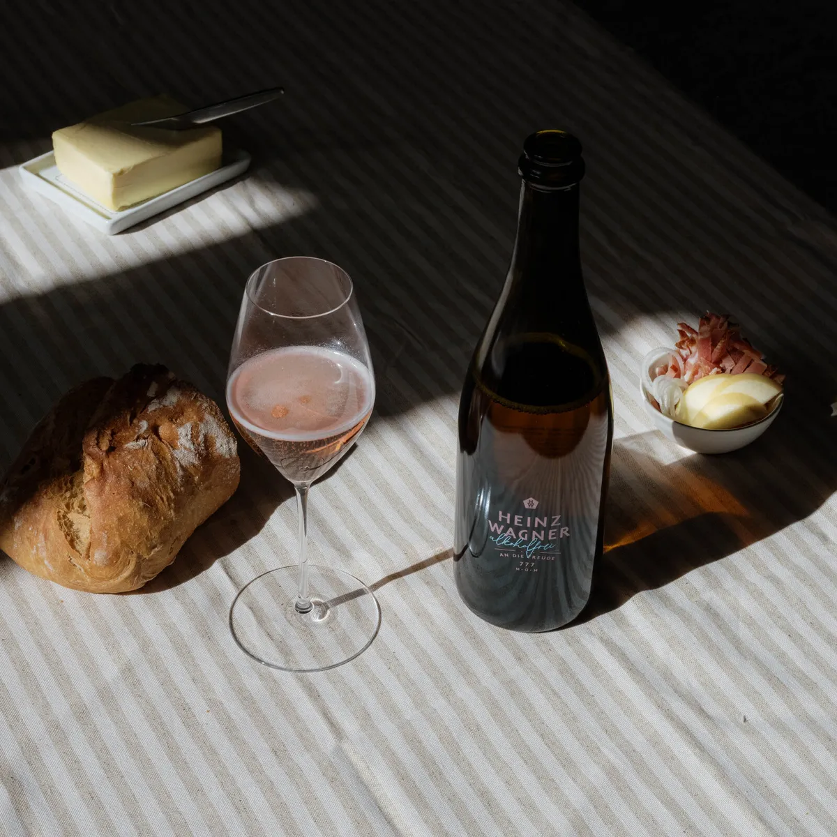 Bottle of Heinz Wagner Alcohol-free with a filled glass, bread and butter on a table